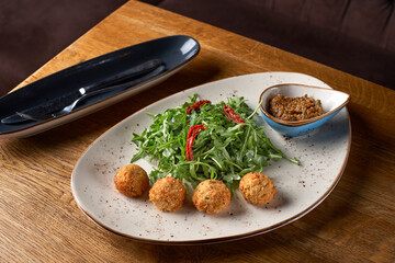 Close up of fresh falafel balls with pesto sauce.
