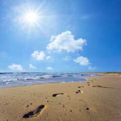sandy sea beach with human track at the sunny day