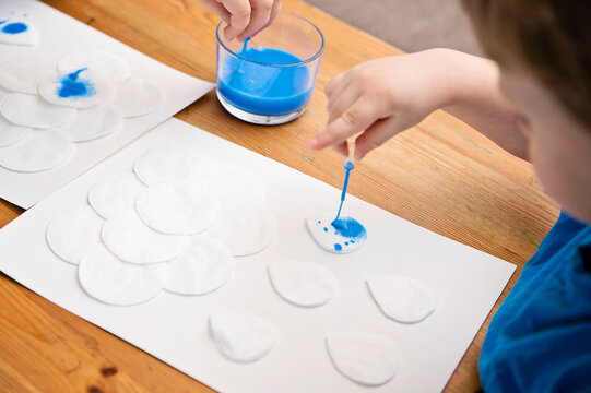 Let's make the rain. Boy coloring drop shape cotton pads. 5 minute crafts for children activities. Creative solutions at home.