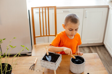 Little gardener loosening soil in ceramic pot