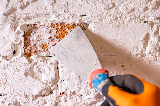 A spatula to remove old paint on the wall. Painting and construction work carried out at home.