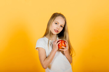 Beautiful blonde girl with red apple in studio