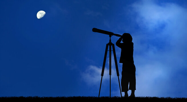 Silhouette of little child looking through a telescope the moon