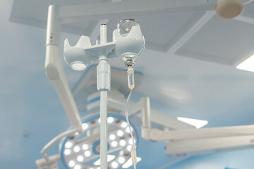A dropper with medication in the operating room against the background of medical equipment.