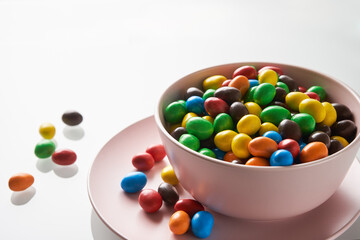 Bright candy drops in a pink bowl. Festive mood.