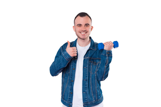 Photo of cheerful young man holding small dumbbell and showing thumb up