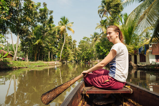 Tourist woman boating on Alleppey backwaters and enjoyin beautiful view