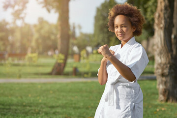 Cute Afro American girl practicing martial arts outdoors