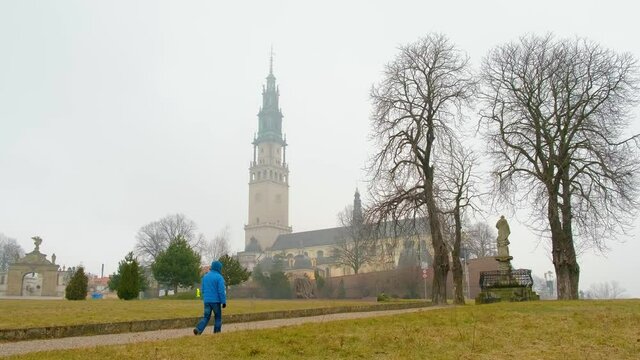 Częstochowa, Lower Silesia Province, Poland-March 2021:Mężczyzna idący po pustym placu przed Sanktuarium Matki Bożej Częstochowskiej na Jasnej Górze