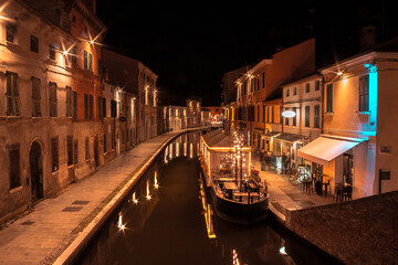 Fototapeta na wymiar Barca trasformata in ristorante all'interno del canale principale di Comacchio, Emilia Romagna