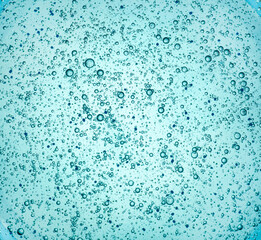 Gel with oxygen bubbles. Abstract blue transparent liquid background. Antibacterial gel, hyaluronic acid. macro close-up
