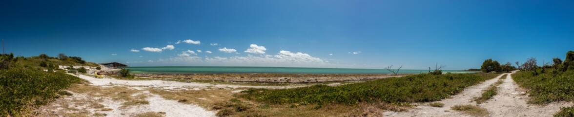 Panorama of beach and turquoise water with blue skies