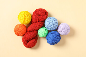 Colorful woolen yarns on beige background, flat lay