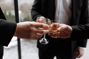 Business meeting. Men hold glasses of whiskey. Men's Party. Hand with a drink of alcohol