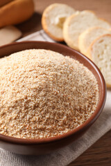 Fresh bread crumbs in bowl on table, closeup