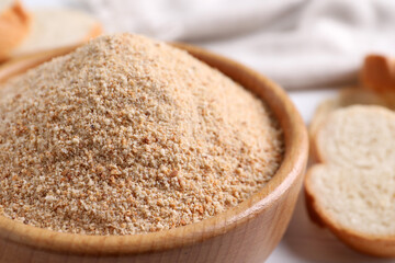 Fresh breadcrumbs in bowl on table, closeup