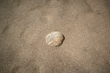 Fototapeta na wymiar Single Rock in Sand Background Texture