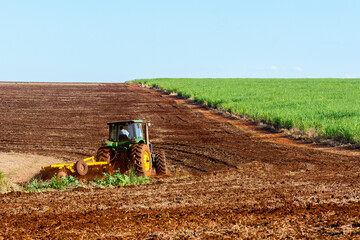 Tractor plowing land to plant sugar cane
