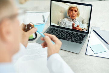 Fototapeta na wymiar Doctor recommending medicaments to patient during online consultation