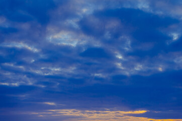 Naklejka na ściany i meble Blue sunset with dark clouds.