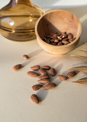 Raw, organic almonds, in a wooden boho style bowl next to palm leaves