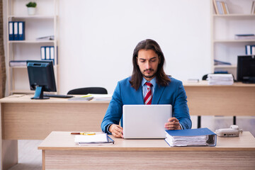 Fototapeta na wymiar Young male employee working at workplace