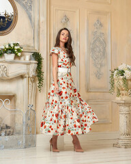 Young beautiful pretty elegant woman with long brunette hair wearing colorful dress with floral...