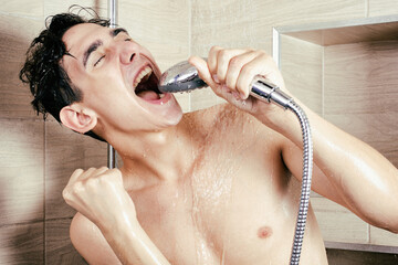 The funny guy is singing in the shower. Parodies and makes grimaces. Athletic body in the water....