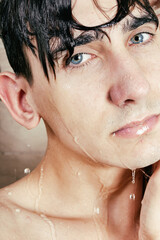 Naklejka premium The athletic guy takes a shower. Body care and hygiene. Foam on the head.