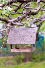 wooden birdhouse bird feeder side view hanging on a branch