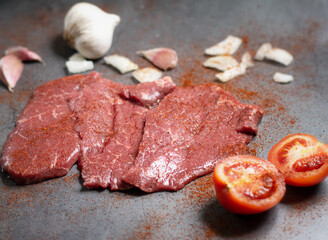 Fresh raw beef steak slices on a stone slate