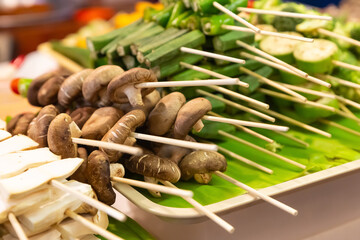 assorted mushroom skewers and vegetables on wooden skewers selective focus