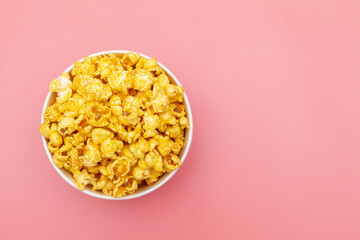 Caramel of pop icons in multicolored cups on pink background
