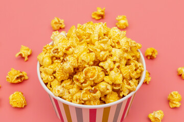 Caramel of pop icons in multicolored cups on pink background