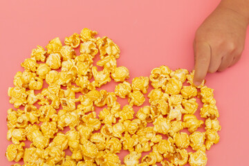 Caramel of pop icons in multicolored cups on pink background