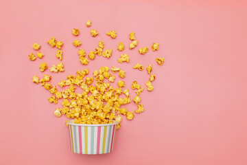 Caramel of pop icons in multicolored cups on pink background