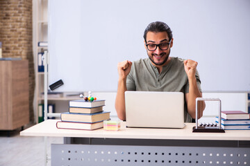 Young male student physicist in tele-education concept