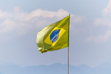 faded brazil flag outdoors on a rio de janeiro beach.