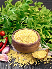 Bulgur in bowl with vegetables on wooden board