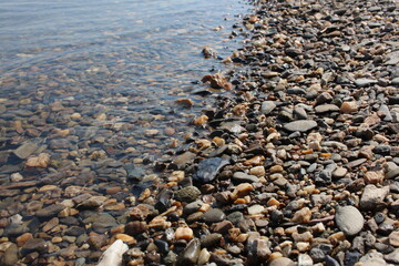 colorful stones on the beach on a rocky beach in the ocean waves