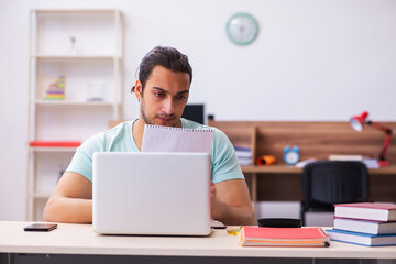 Young male student preparing for exams at home in tele-education
