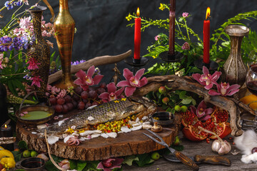 Still life in old masters style with fish, glass of wine, old dishes, fruits. The concept of a richly decorated table.