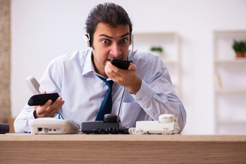Young male call center operator working at his desk