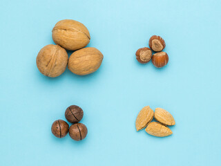 Four types of nuts on a light blue background. Flat lay.