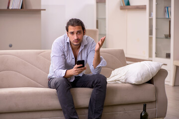 Obraz premium Young drunk man suffering at home