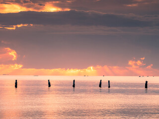 Sunrise Over The Sea with Old Pylons