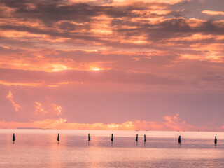 Sunrise Over The Sea with Old Pylons