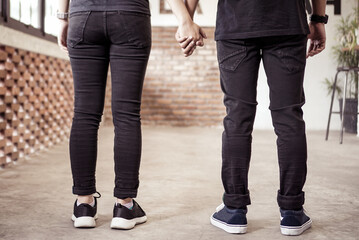 Back view of romantic young couple holding hand 