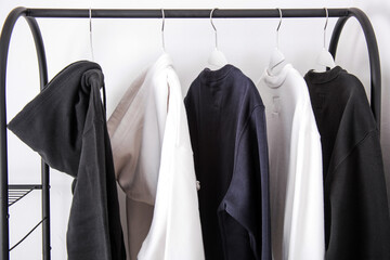 Various outwear such as hoodie and sweater hanging on hanger clothes