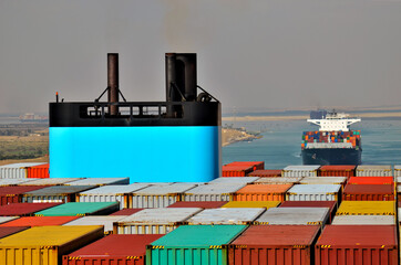 Container ship transiting through Suez Canal. View on the funnel standing above loaded containers. 